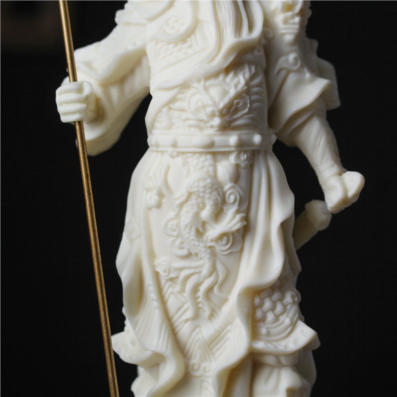 Close-up ivory nut Guan Yu armor carving with dragon and cloud details, natural tagua vegetable ivory sculpture