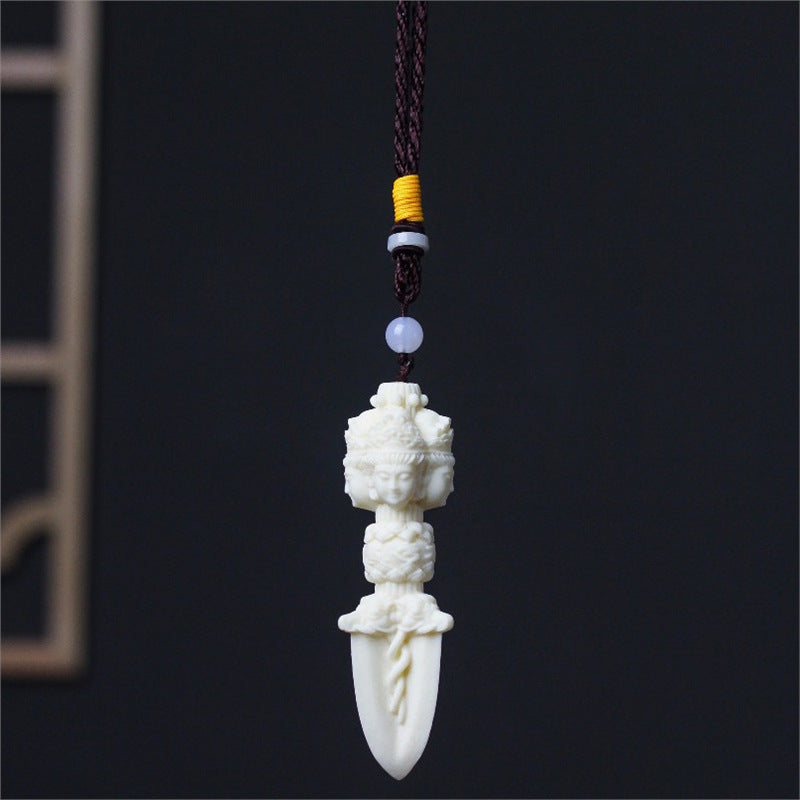 Ivory nut Jiangmo Chu ritual-dagger-inspired pendant showing serene multi-faced carving and pointed blade form, tagua vegetable ivory cultural ornament