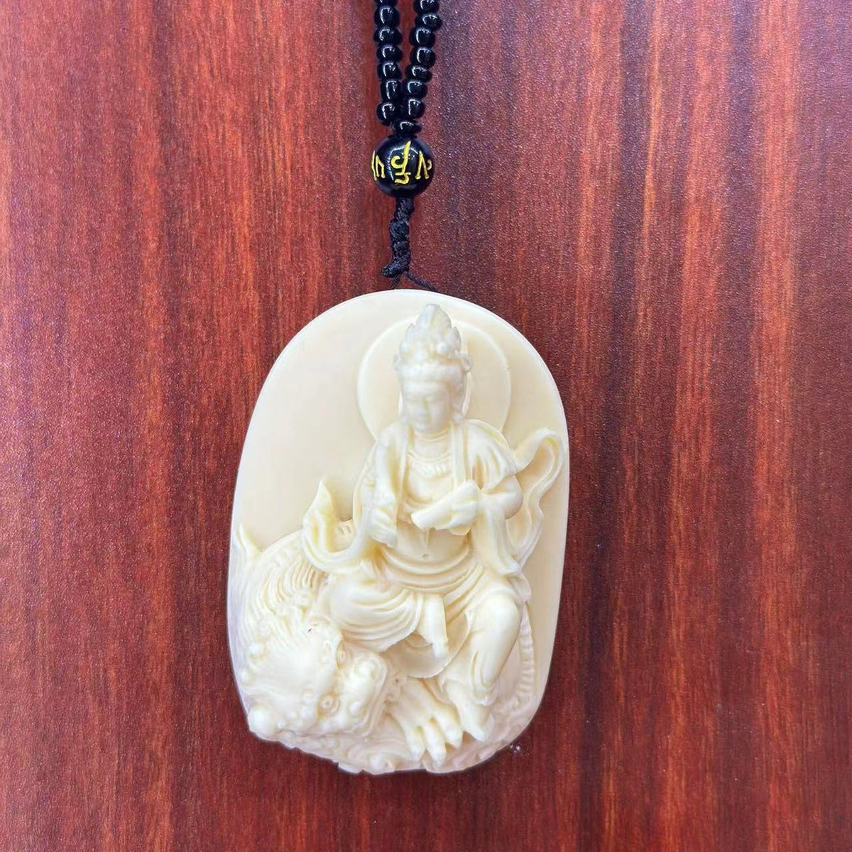 Ivory nut Manjushri Bodhisattva riding a lion pendant, tagua vegetable ivory Chinese Buddhist carving and hanging ornament
