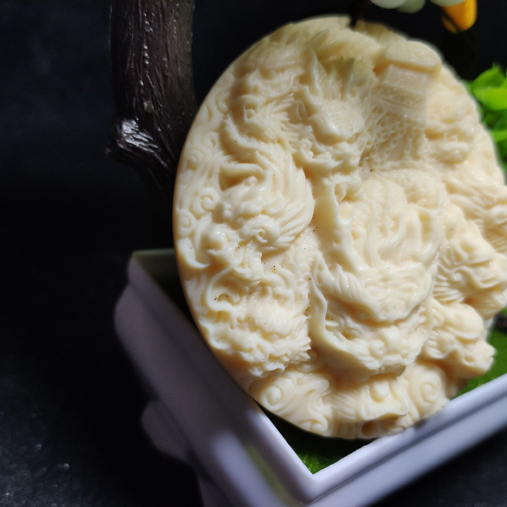 Close-up ivory nut Nine Dragons and Ancient Coffin fantasy carving, tagua vegetable ivory Chinese dragon relief pendant detail