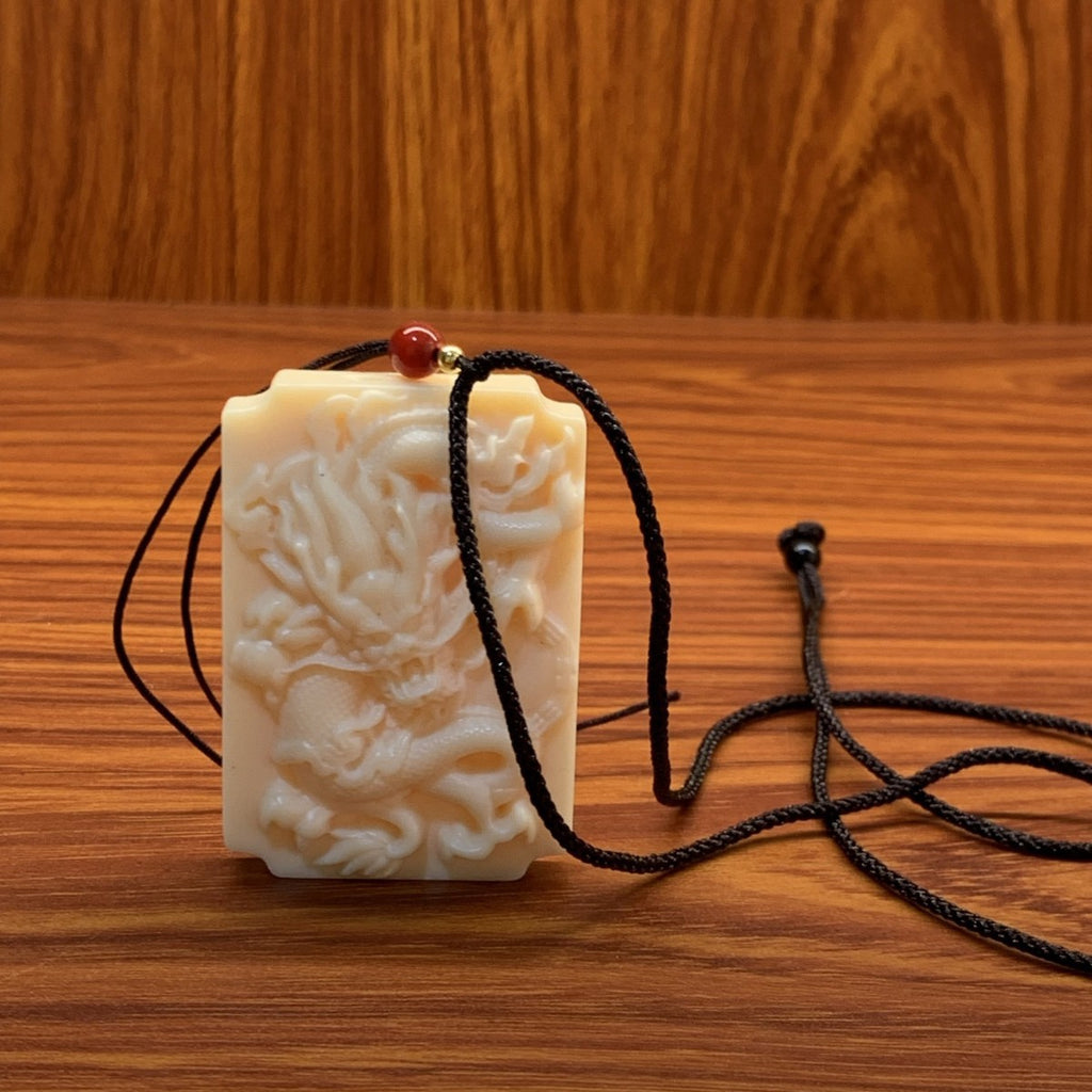 Ivory nut Dragon plaque pendant with black cord, tagua vegetable ivory Chinese dragon relief carving approximately 3.7 × 1 × 5.5 cm