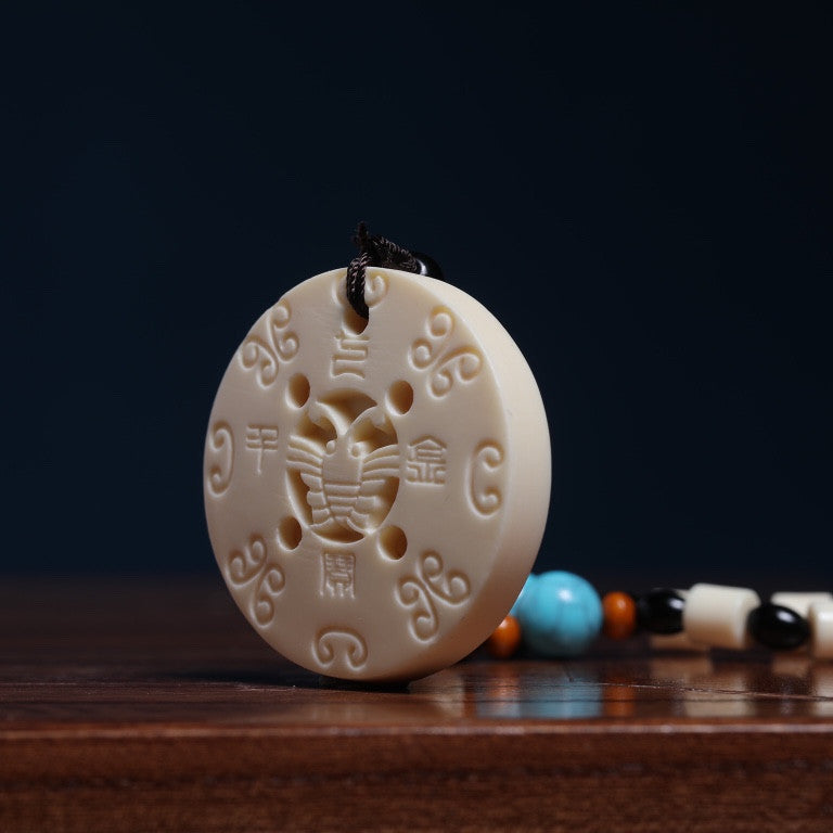 Side detail of ivory nut Qibao Qianjin peace buckle ornament, tagua vegetable ivory round Chinese hanging carving approximately 5 cm