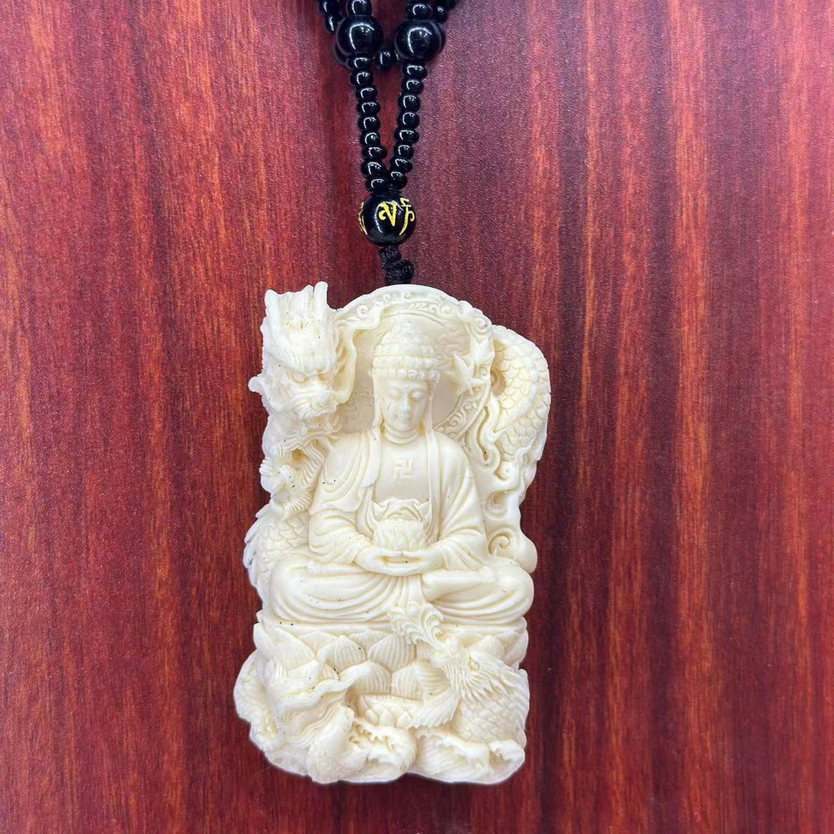 Ivory nut Shakyamuni Buddha with dragon carving on black bead cord, tagua vegetable ivory Chinese Buddhist pendant and hanging ornament