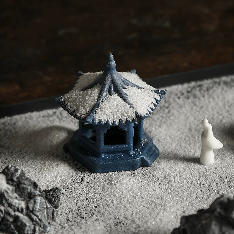 Miniature pavilion and contemplative figure detail in zen sand tray