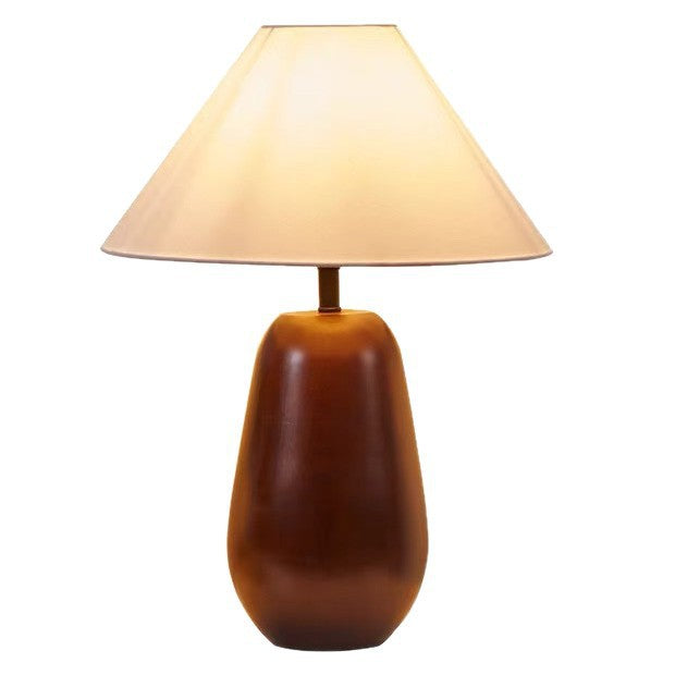 Warm brown rounded solid wood table lamp with tapered cream fabric shade