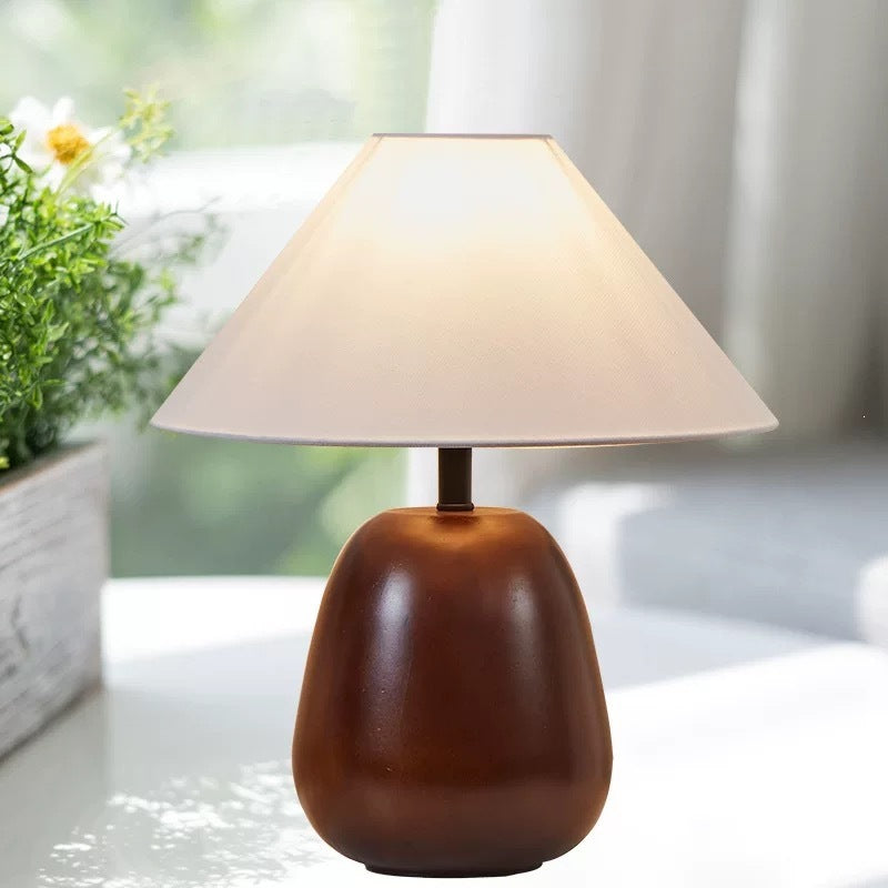 Japanese-inspired rounded wood table lamp beside a window