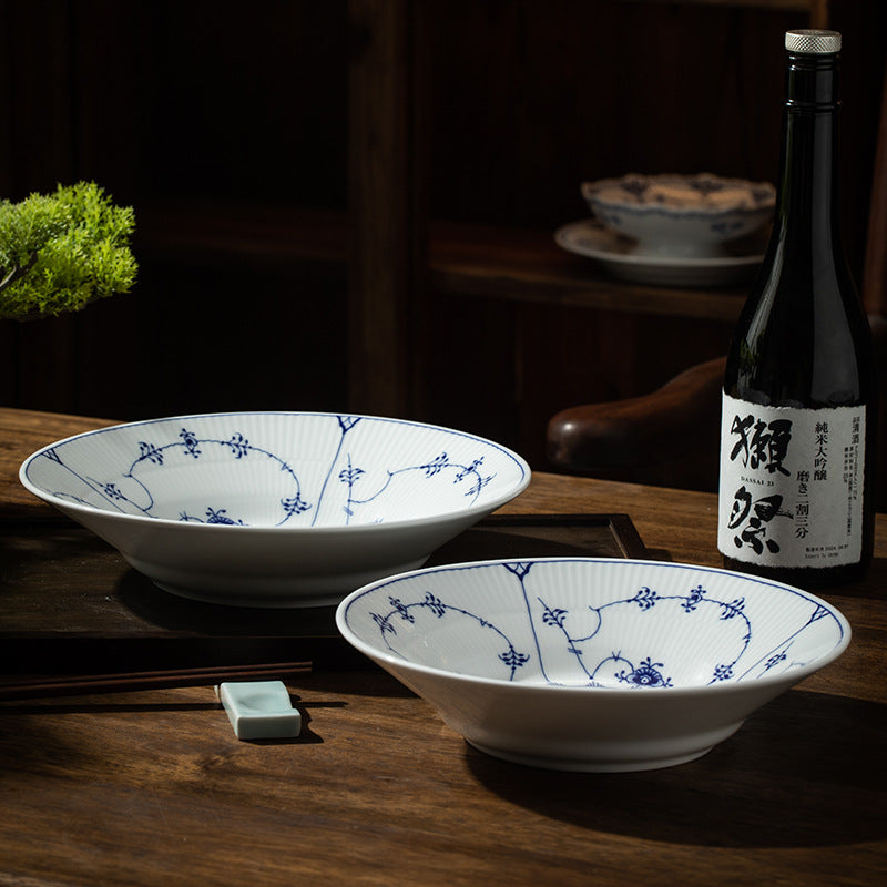 Jingdezhen blue and white Tangcao deep porcelain bowls styled on a dark wood dining table