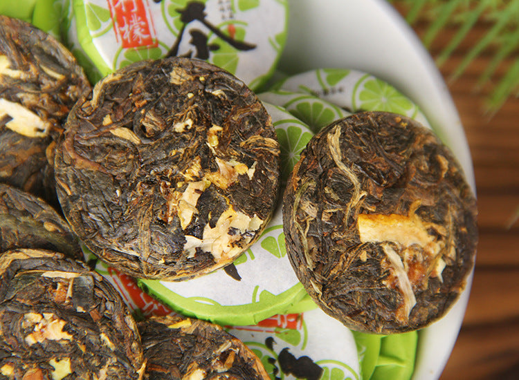 Close-up of compressed Dianhong black tea mini cakes blended with lemon pieces