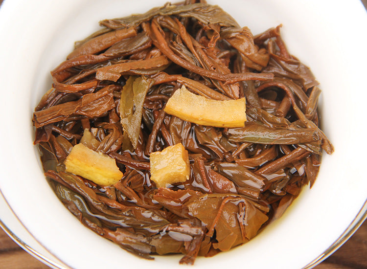 Brewed Yunnan Dianhong lemon black tea leaves with visible lemon pieces