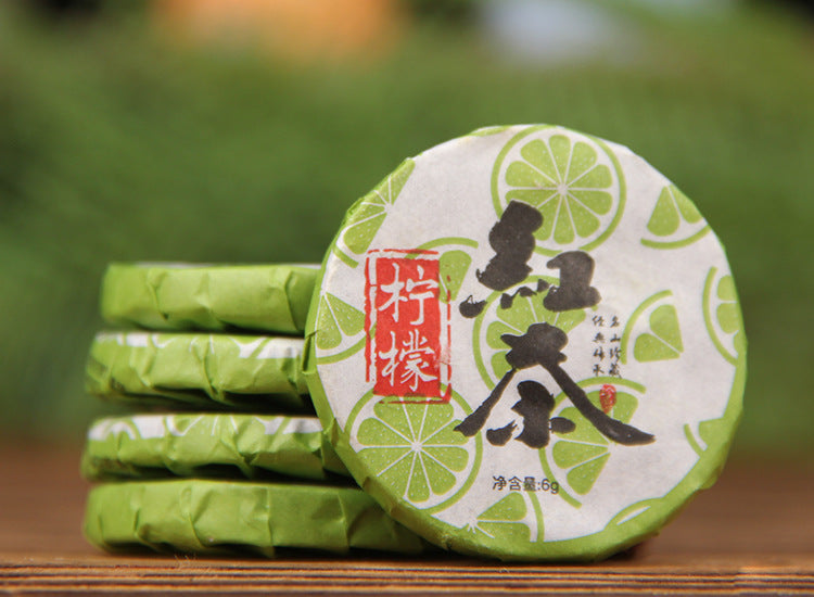 Individually wrapped lemon Dianhong black tea mini cakes in green citrus-themed wrappers