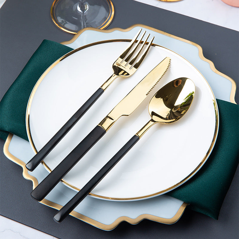 Mist blue irregular square plate layered with gold-rim round plate and black-handle gold cutlery