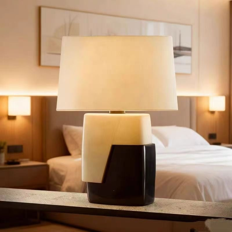 Black ivory geometric designer table lamp styled in a warm luxury bedroom