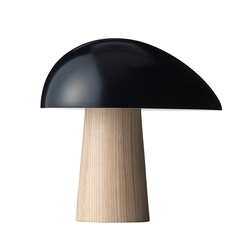 Black mushroom table lamp with natural wood-look tapered base on white background