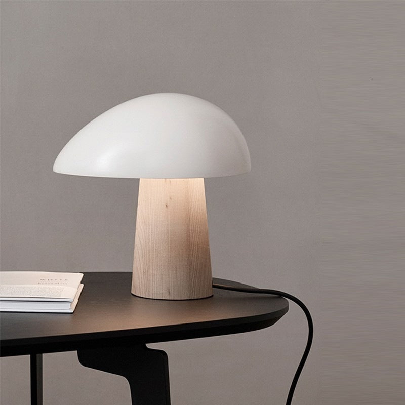 White dome mushroom table lamp with natural wood-look base in a minimalist interior