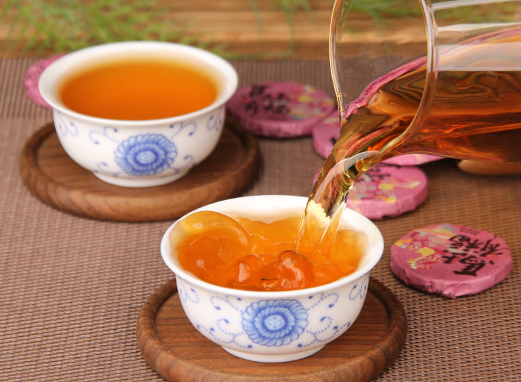 Brewed nuo mi xiang Yunnan black tea with pink mini tea cake wrappers