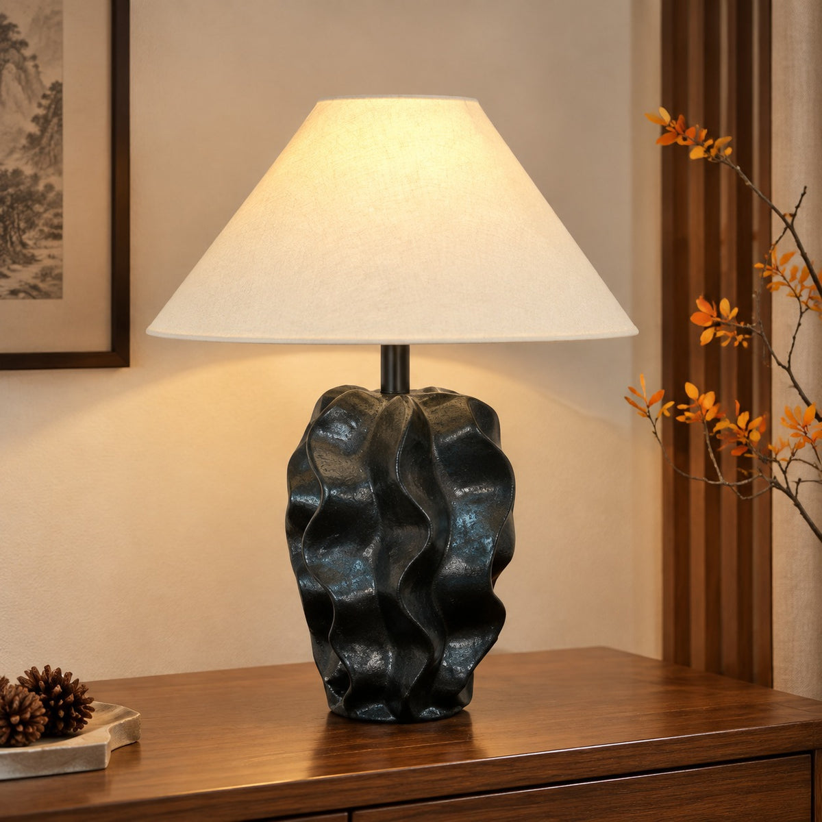 Organic black rock-form ceramic lamp with cream linen shade on a timber console