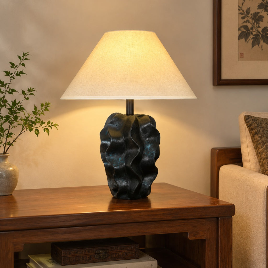 Black abstract ceramic lamp with warm fabric shade in a calm contemporary interior
