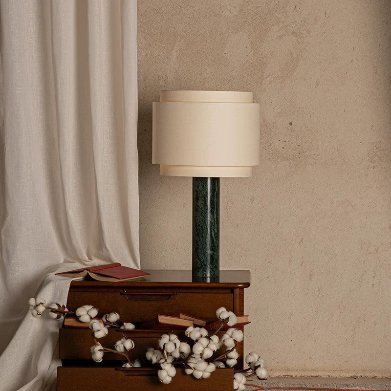 Olive green marble column table lamp with layered cream drum shade in a refined interior