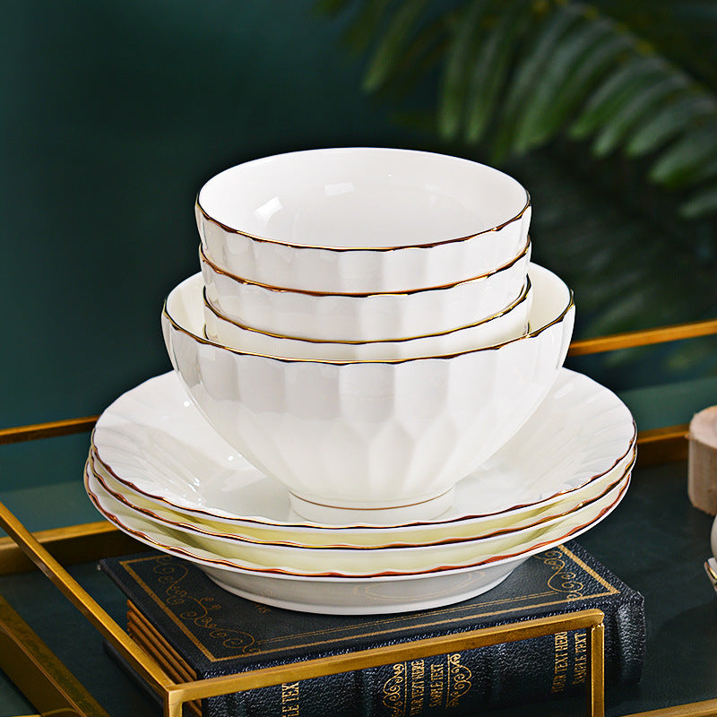 Stacked Shuijing Zhilian white embossed bone china bowls and plates with gold edging