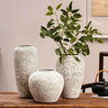 Snowfall speckled ceramic vase collection styled with green branches