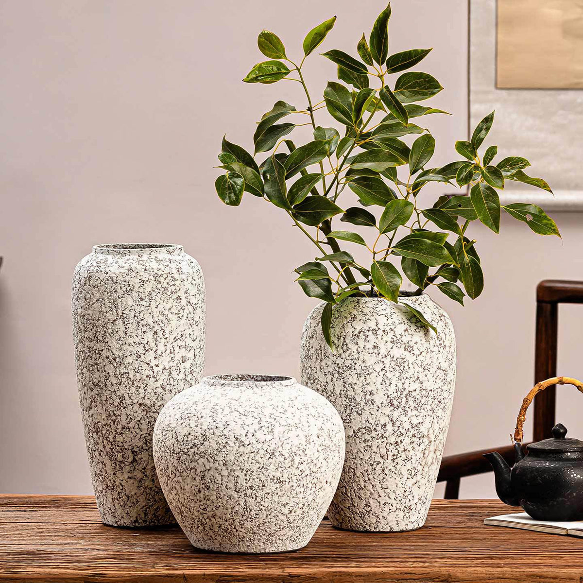 Snowfall speckled ceramic vase collection styled with green branches