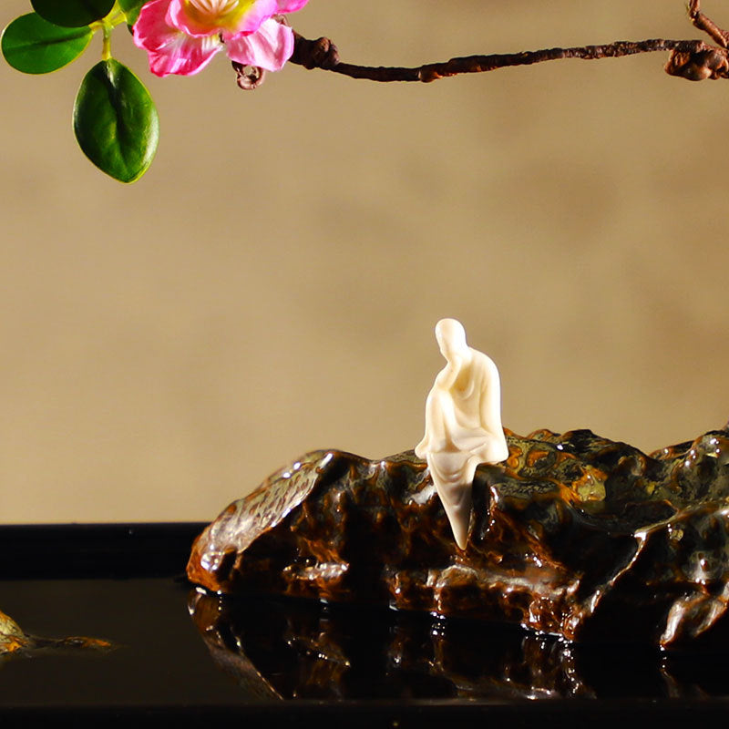 Close detail of Spring Eye zen water feature with seated figure