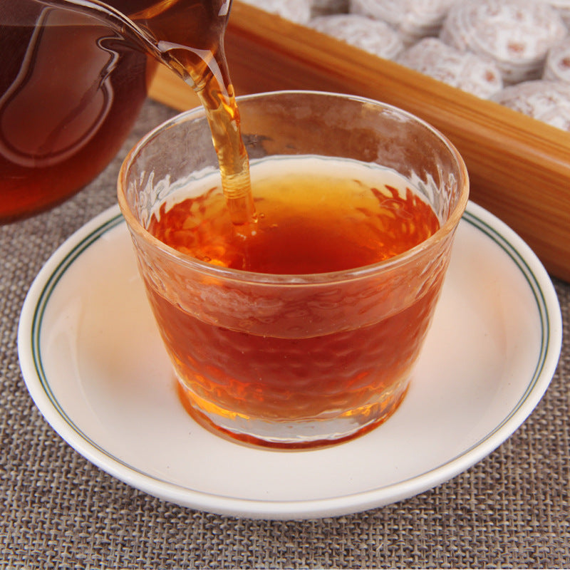 Amber tea liquor brewed from sticky rice aroma ripe Pu-erh mini tuocha