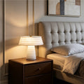 White layered faux alabaster resin table lamp used as warm bedside lighting