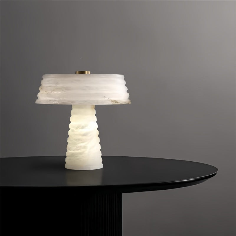 Layered white faux marble resin table lamp on a black round console