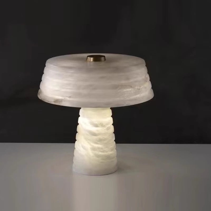 Sculptural white ribbed faux alabaster lamp against dark background