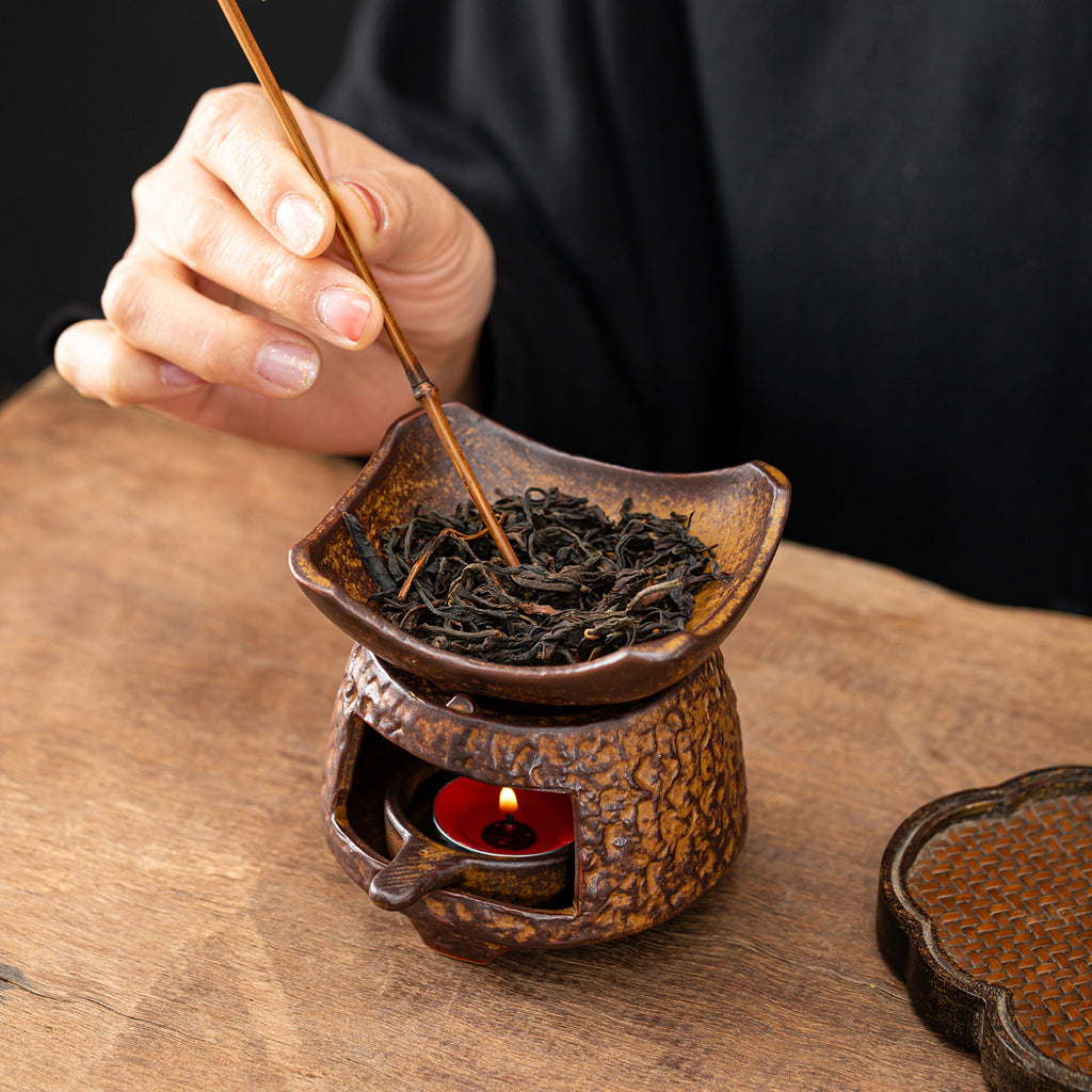 Ceramic tea leaf roasting warmer in use with dried tea leaves