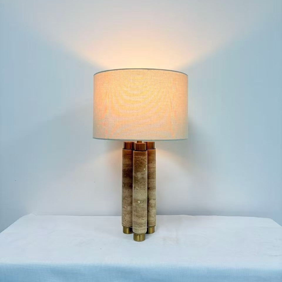 Travertine and brass column lamp with warm illuminated fabric shade