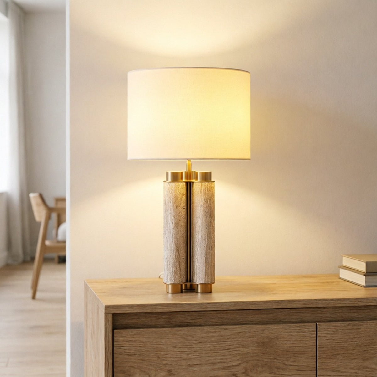 Natural stone column table lamp with brushed brass accents on a wood console