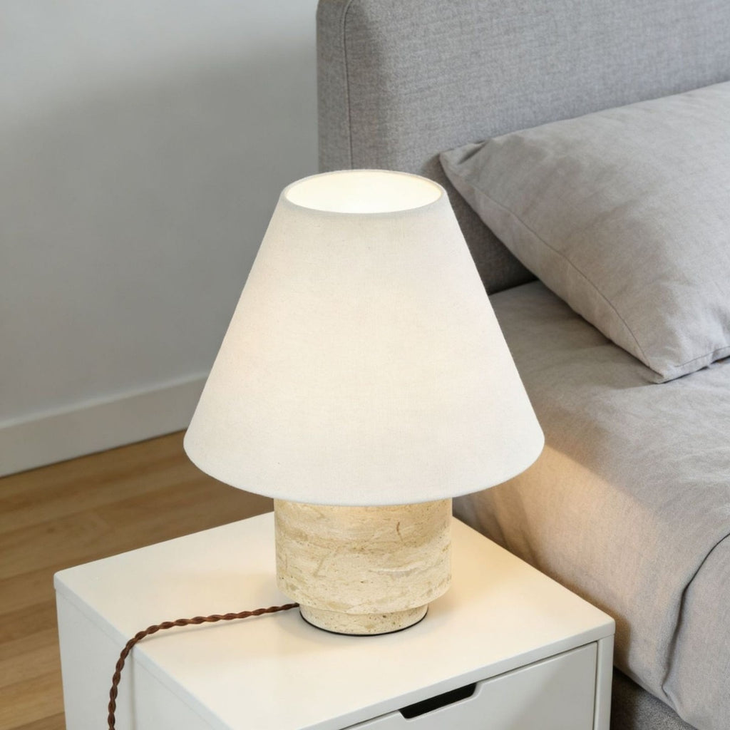 Compact natural travertine table lamp used as warm bedside lighting