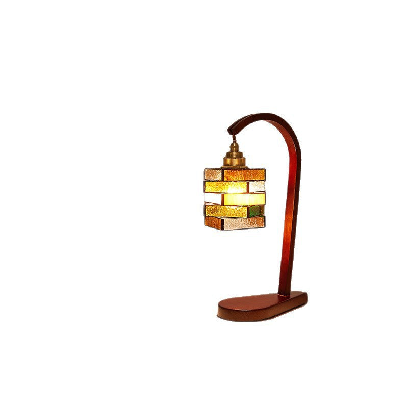 Curved walnut-finish table lamp with geometric colored glass lantern shade