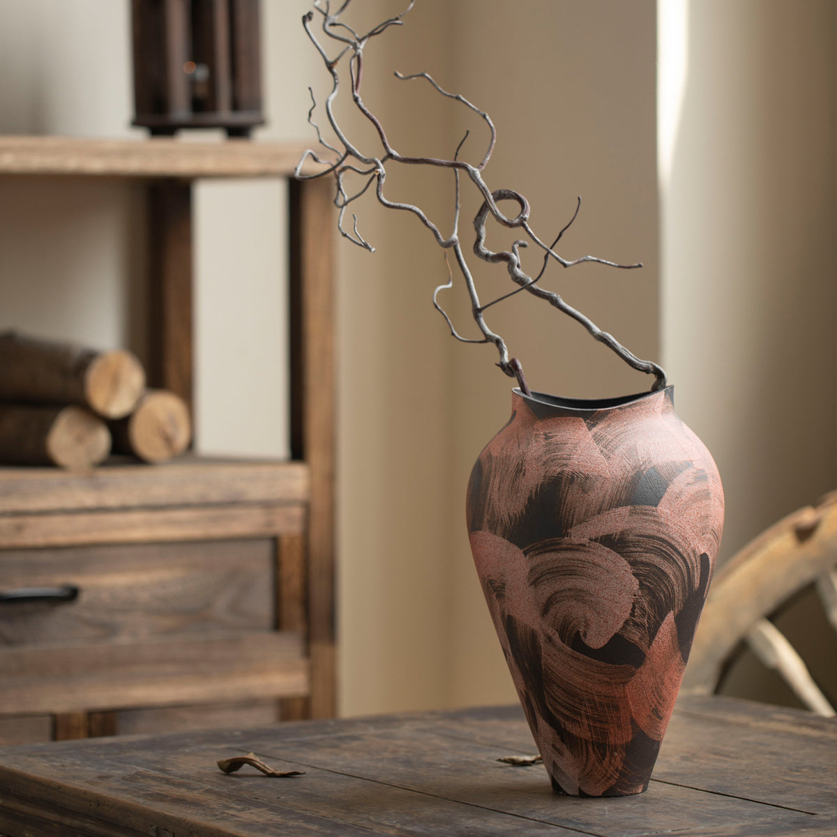 Warm brushstroke ceramic vase styled with sculptural dry branch