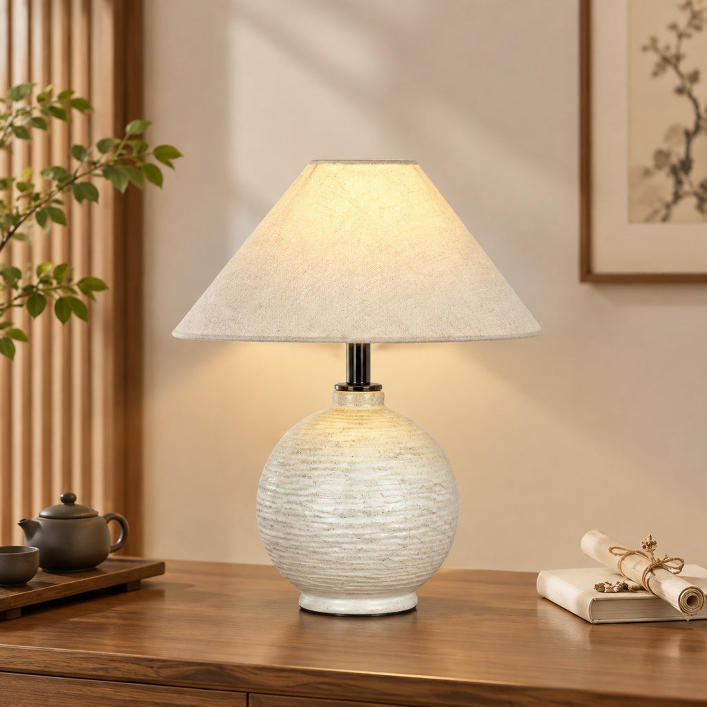 Round white textured ceramic table lamp styled with tea ware and warm wood furniture