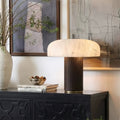 Faux alabaster dome table lamp with dark woven-texture column on a black console