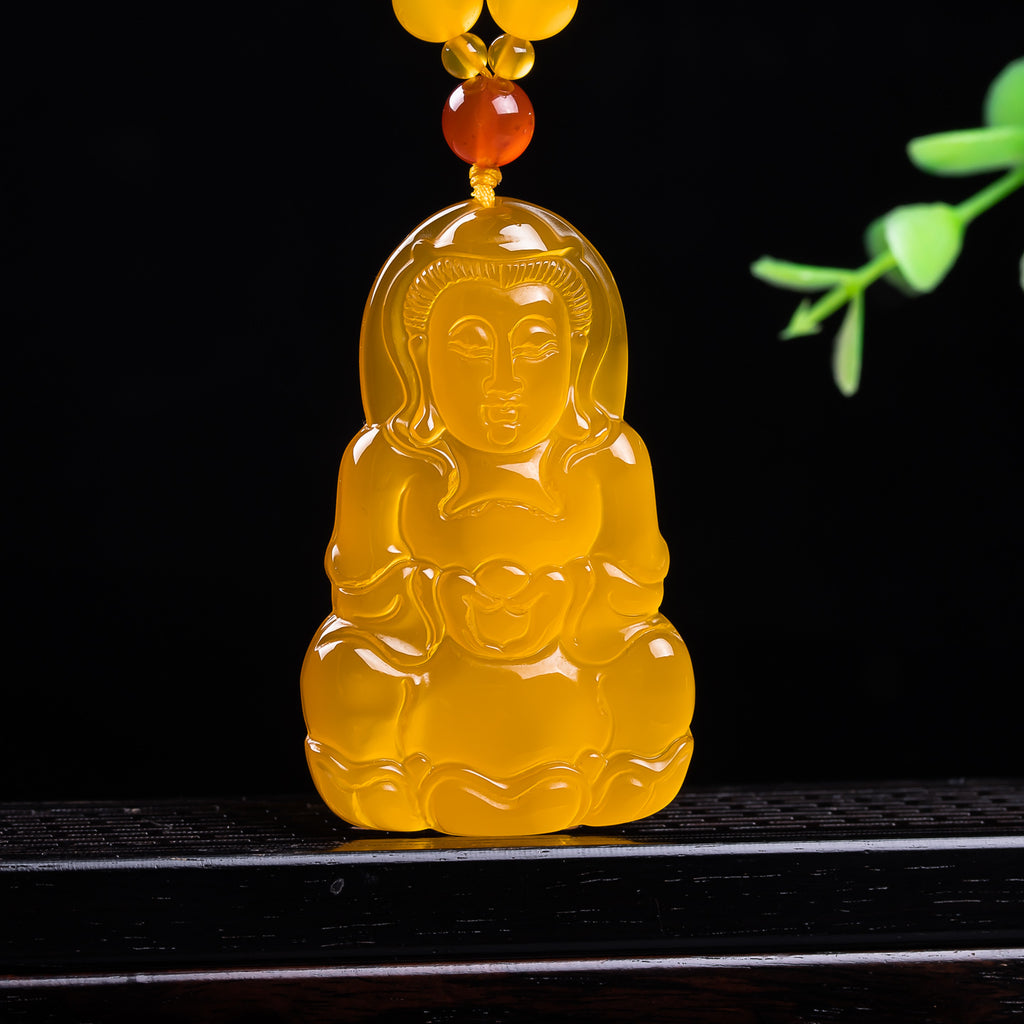 Golden yellow chalcedony seated Guanyin pendant translucent stone close-up