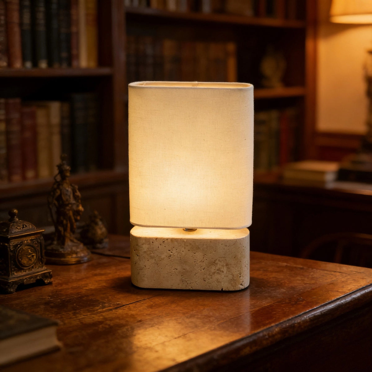 Yellow travertine lamp with warm fabric shade styled on a classic wood study desk