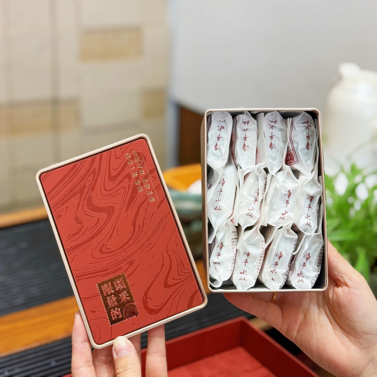 Individually wrapped compressed Zhangping Shui Xian tea cakes in red tin