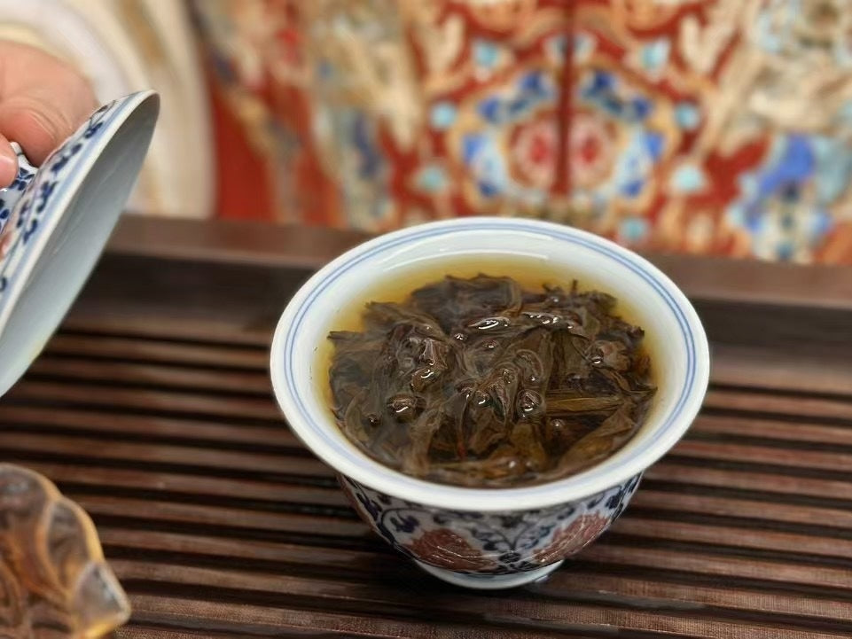 Opened Wuyi rock oolong leaves in covered tea bowl